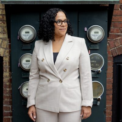 Diana Hernández stands in front of a wall of energy meters