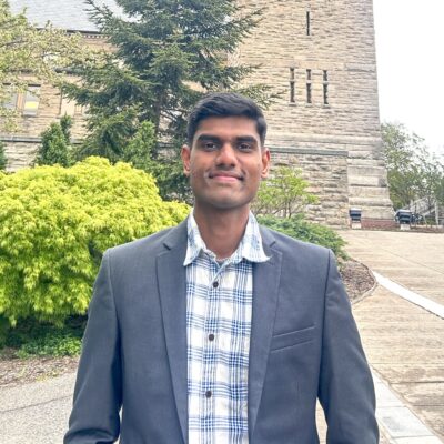 Divyanth Loganathan Girija stands in front of McGraw Tower