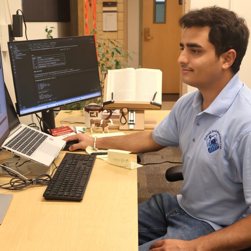 Sumit Sharma sits in front of several computer screens