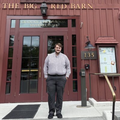 Trevor McClenon stands outside the front door of the Big Red Barn Graduate and Professional Student Center