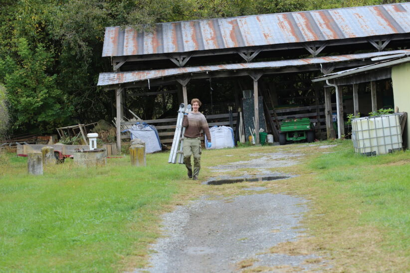 Lorenz Mammen walks away from a structure, carrying a ladder