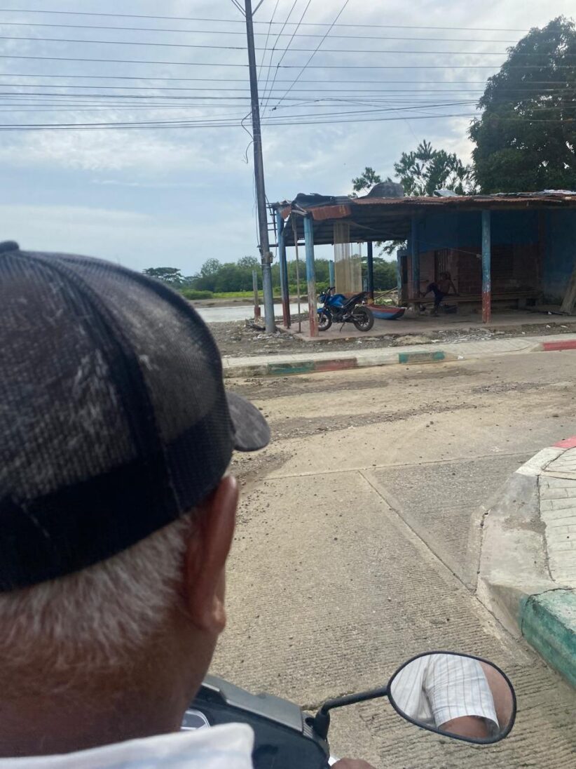 A man seen from the back looking at a run-down looking structure